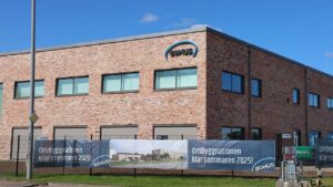 Fasadskylt för Bohus ombyggda fastighet på Exportgatan, Hisings Backa. Blå och svart fasadskylt där de svarta tecknen lyser med vit ljuseffekt på natten.