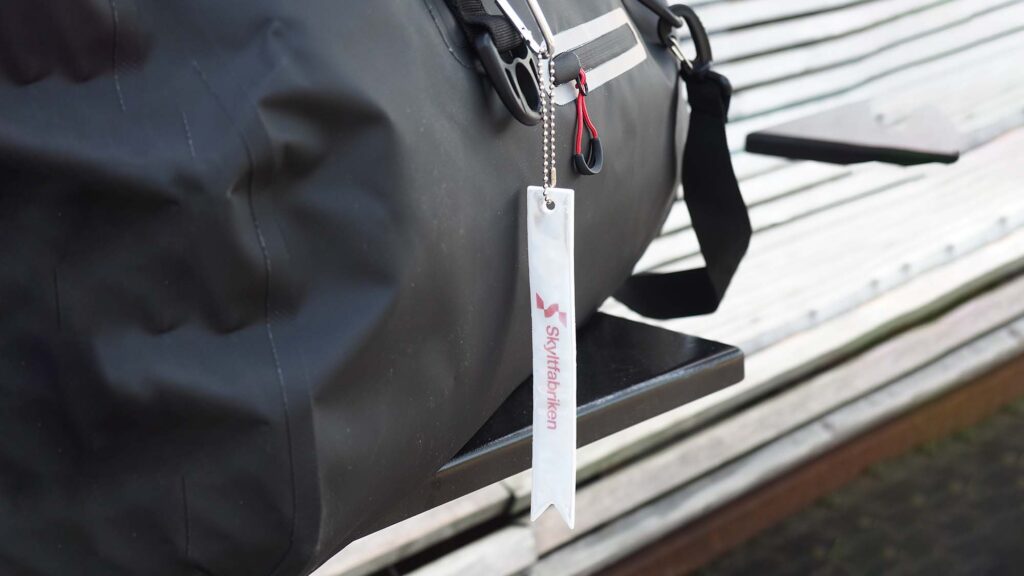 Reflex med karbinhake för väska eller jacka. Välj ett eget tryck, till exempel företagets logotype.