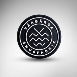 Ett runt märke i gummi med upphöjd text, för väska, ryggsäck, mössa eller keps.