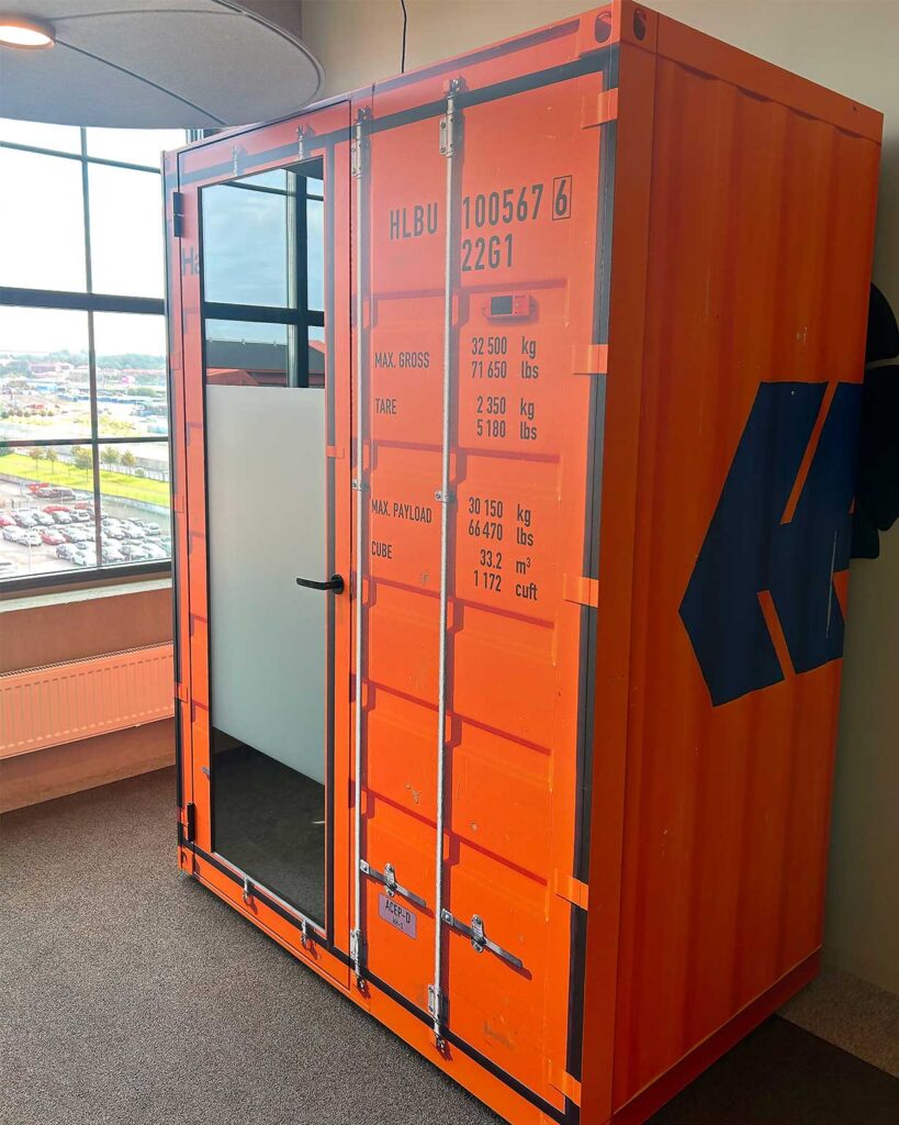 Anpassad Sono Work-pod från Martela - En pod som fungerar som telefonbås, mötesrum eller videosamtal. Här wrappad med printad folie för att likna en container från Hapag Lloyd. Kul design på kontoret!