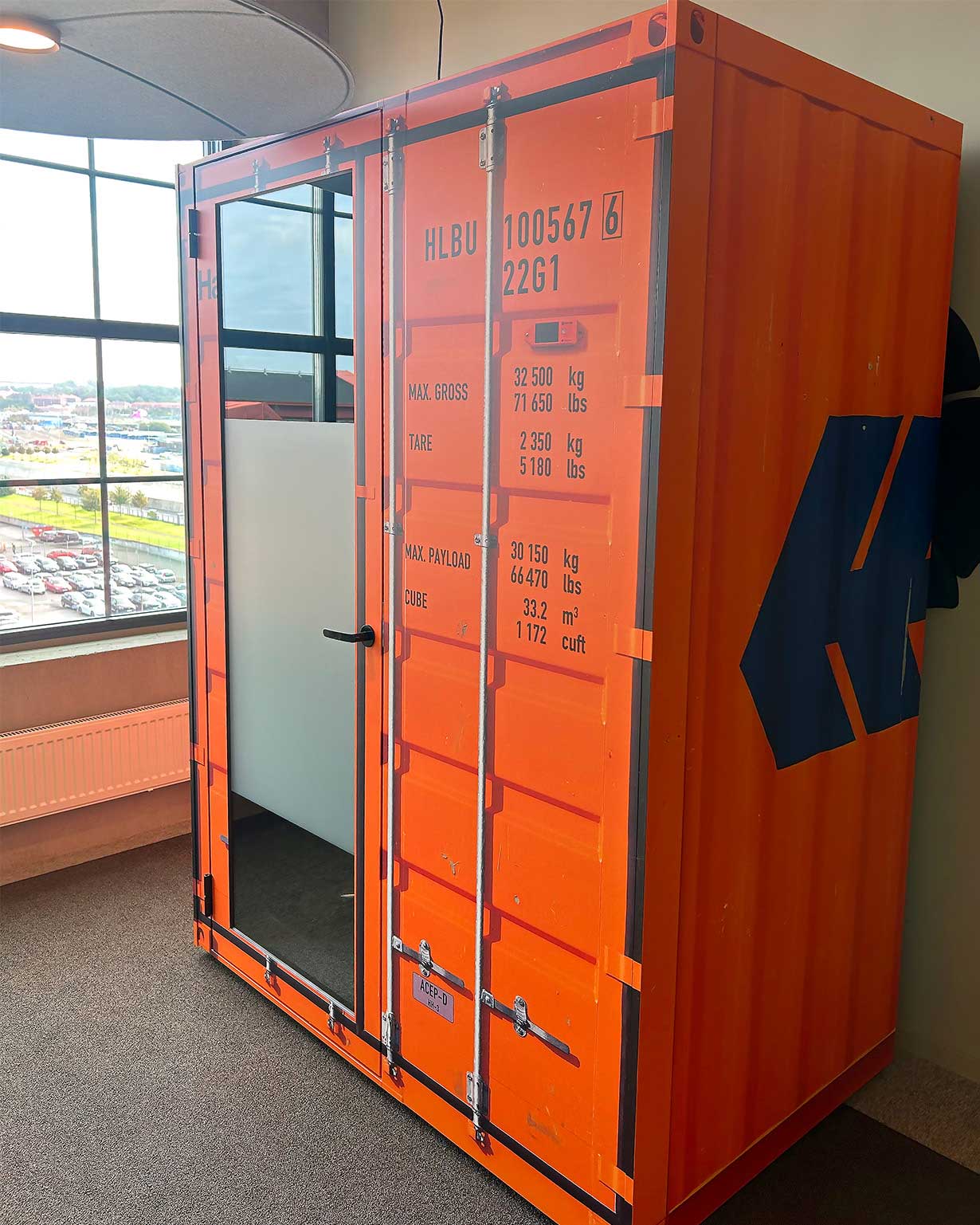 Anpassad Sono Work-pod från Martela - En pod som fungerar som telefonbås, mötesrum eller videosamtal. Här wrappad med printad folie för att likna en container från Hapag Lloyd. Kul design på kontoret!