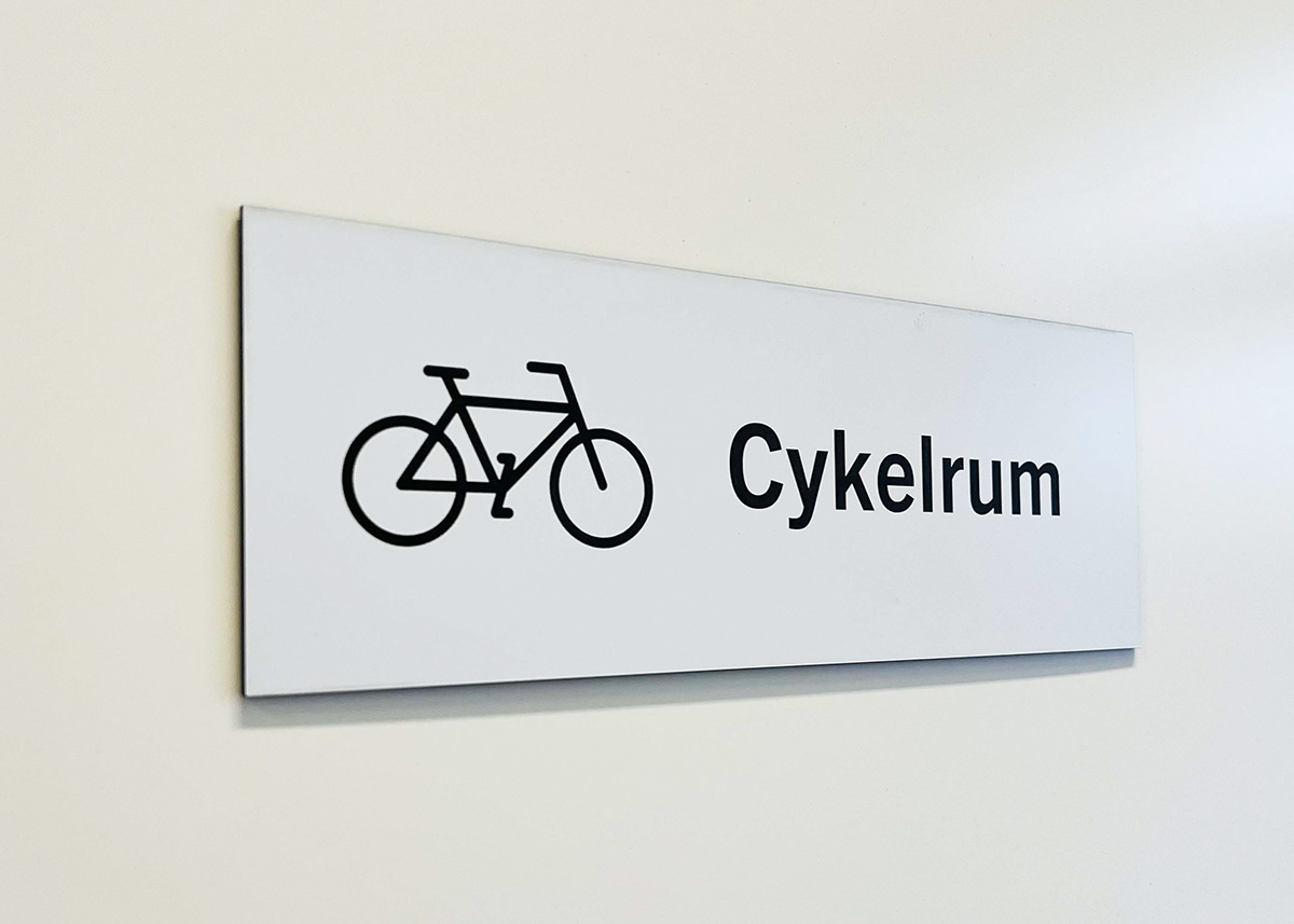 Rumsskylt för cykelrum. En skylt hjälper till att hänvisa personal, kunder eller besökare rätt i lokalen. Sätt rumsskylten på väggen bredvid ett kontor, rum eller sal och besökaren vet vad det är för rum.